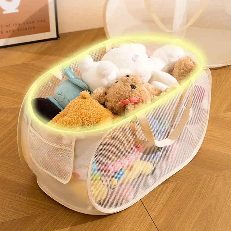 A translucent white mesh toy storage basket with beige handles and large capacity filled with stuffed animals.