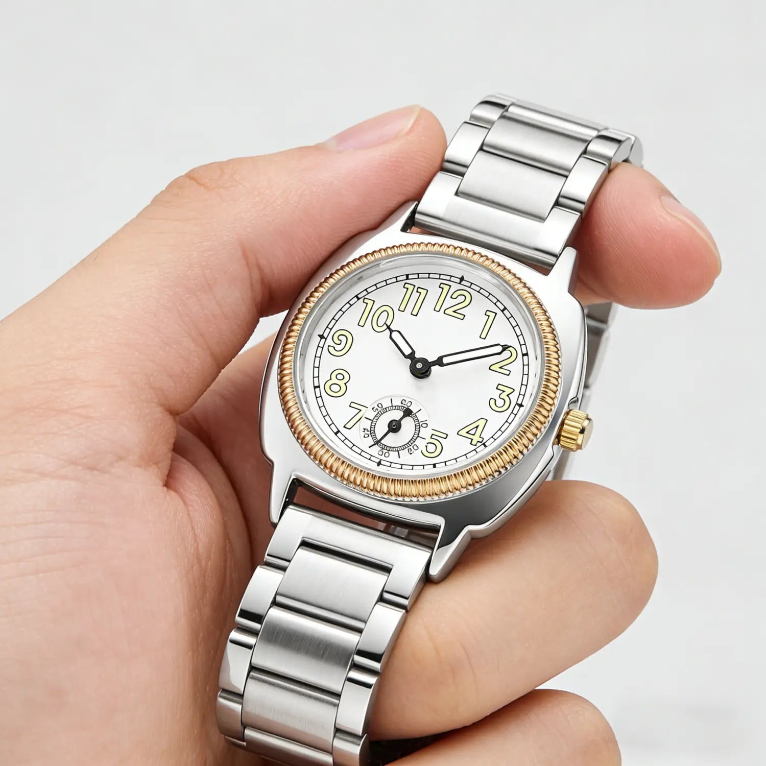 A sleek silver and gold-tone stainless steel analog wristwatch for women with a white dial black hour markers and a textured bezel.