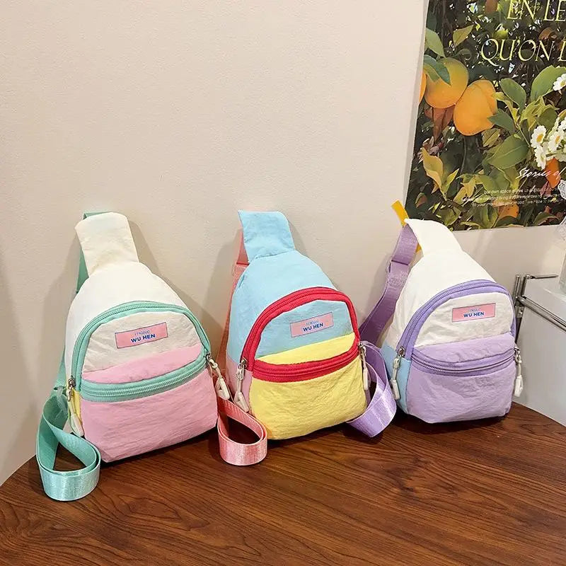 Pastellfarbene Kinder-Umhängetaschen zeichnen sich durch eine leichte, weiche Materialkonstruktion mit auffälligen, gestreiften Paneelen aus und sind als stilvolles und bequemes Brustbeutel-Zubehör gestaltet.