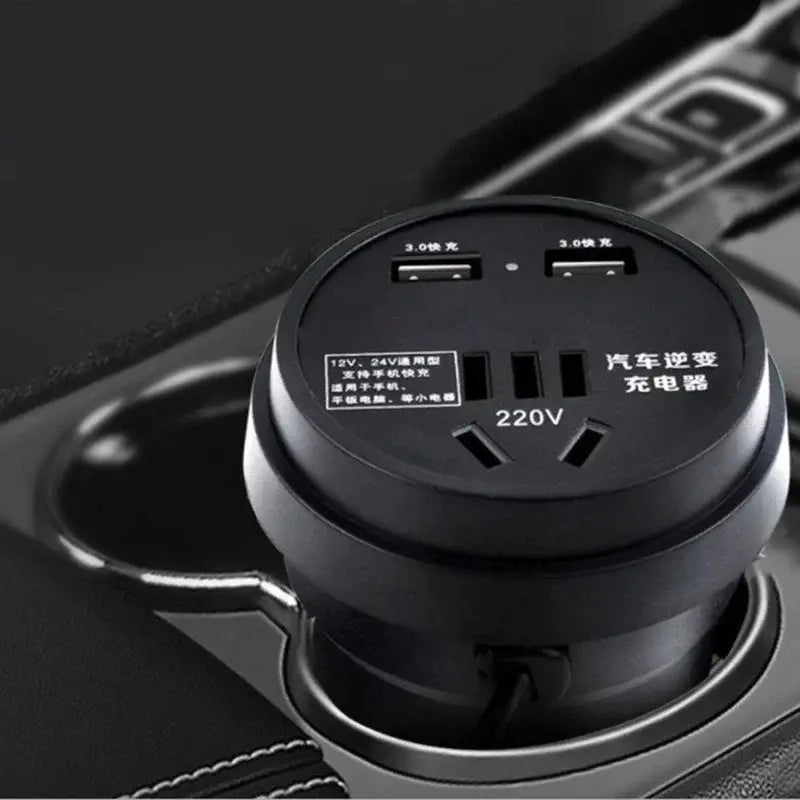 Onduleur de voiture circulaire noir 12 V / 24 V vers 220 V avec prise type gobelet et deux ports USB 3.0, ainsi qu’une prise secteur 220 V c.a., conçu pour charger des téléphones et de petits appareils électroniques dans les véhicules.