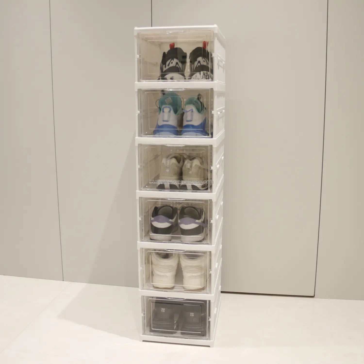 white stackable shoe organizer storage boxes with clear lids displaying pairs of sneakers for efficient shoe storage during working time