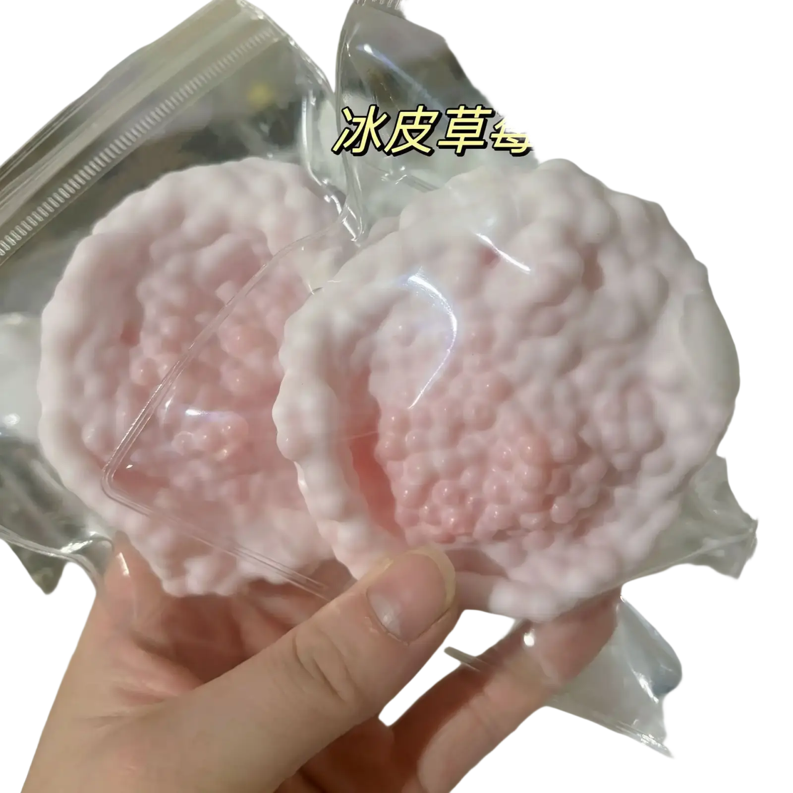 un sachet en plastique transparent contenant un jouet anti-stress souple en forme de peau de neige à la texture duveteuse rose, en forme de glace, de sel de mer, vu de face