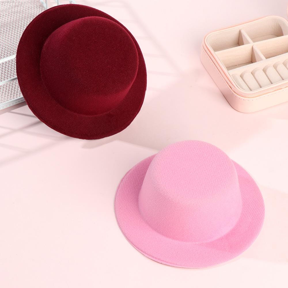 Un fedora bordeaux doux et velouté, à calotte arrondie et bord légèrement incurvé, conçu comme accessoire de mode pour chapeau de poupée en peluche pour des poupées de 60 cm.