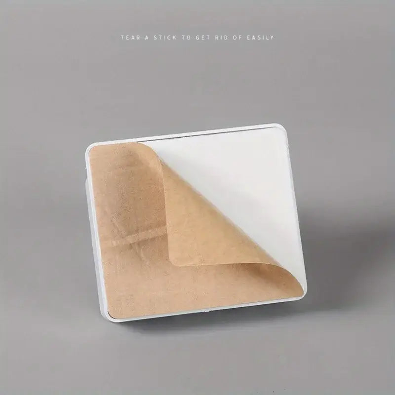 white wall mount phone charging holder showing the adhesive bandage with brown paper backing designed for easy removal on the back side of the product