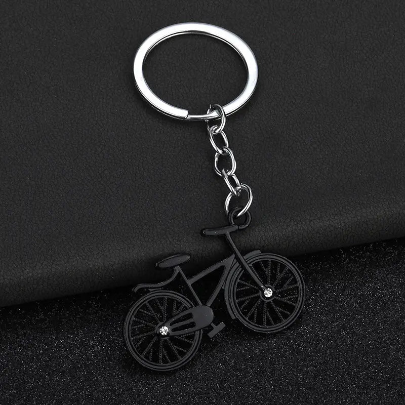 Black bicycle keychain charm set with silver metal ring and chain featuring small crystal accents on the wheels.