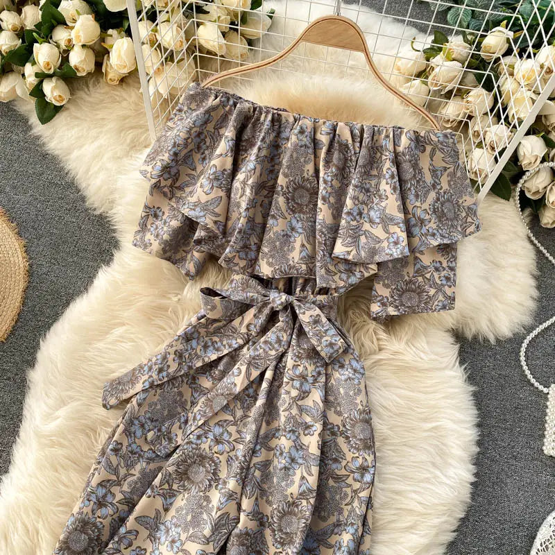 Enterizo de pierna ancha con estampado floral beige y gris y escote tipo bardot, con mangas con volante y cinturilla atada, mostrado desde el frente