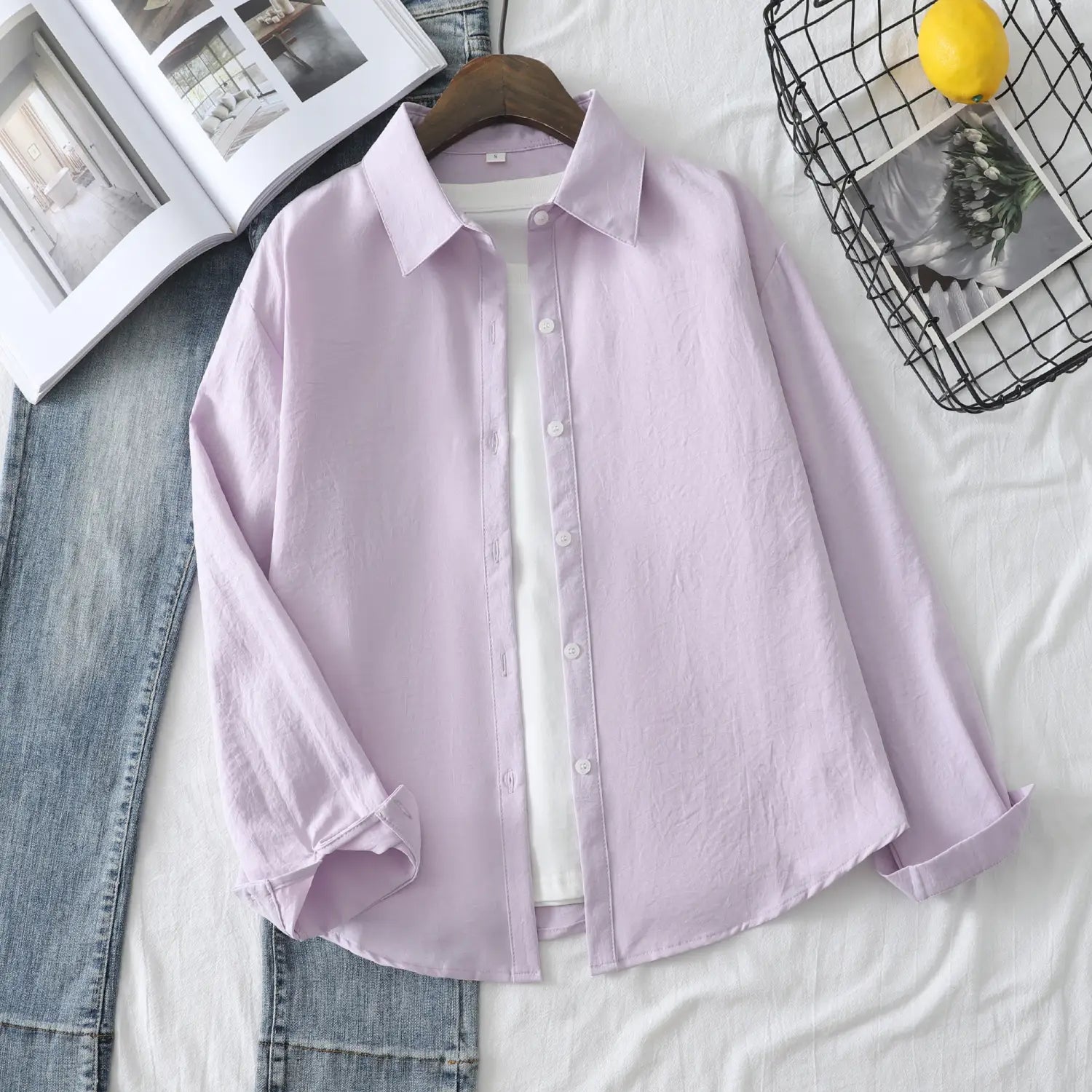 Eine weich lavendelfarbene Damen-Casualbluse aus Baumwollmischgewebe mit langen Ärmeln mit klassischem Kragen und ordentlich umgeschlagenen Bündchen.