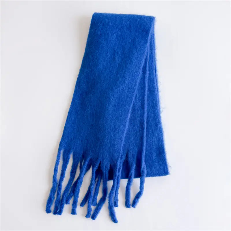 Ein Damenschal mit Cashmere-ähnlichem Gefühl für den Winter in sattem Königsblau mit weicher Textur sowie Fransen aus passendem Garn-Tassel.