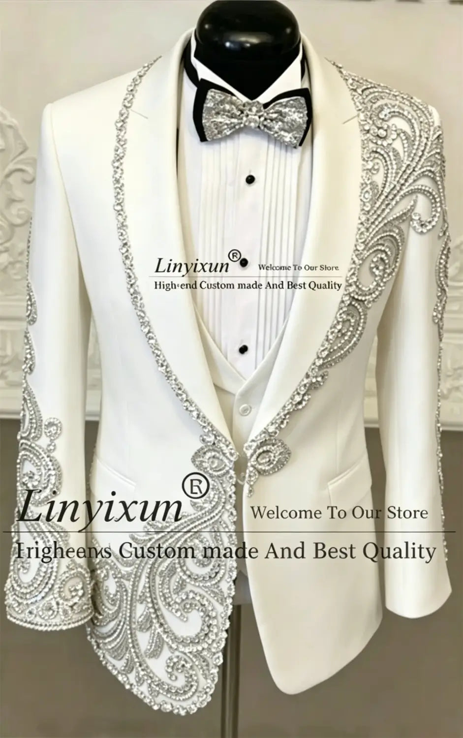 Veste de tuxedo blanche, avec une broderie paisley argentée complexe de perles sur les revers, les épaules et les poignets, faisant partie d’un costume de tuxedo de mariage pour hommes en velours noir à sequins brodés de perles.