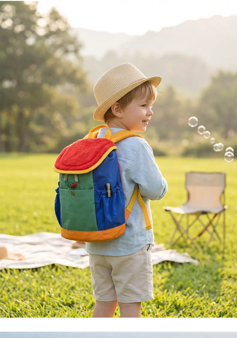 Ein lebhaft mehrfarbiger leichter Fuzzy-Rucksack für Kinder mit rotem oberen Klappteil und gelber Verzierung, entworfen für die Verwendung als Kindergartentagesrucksack