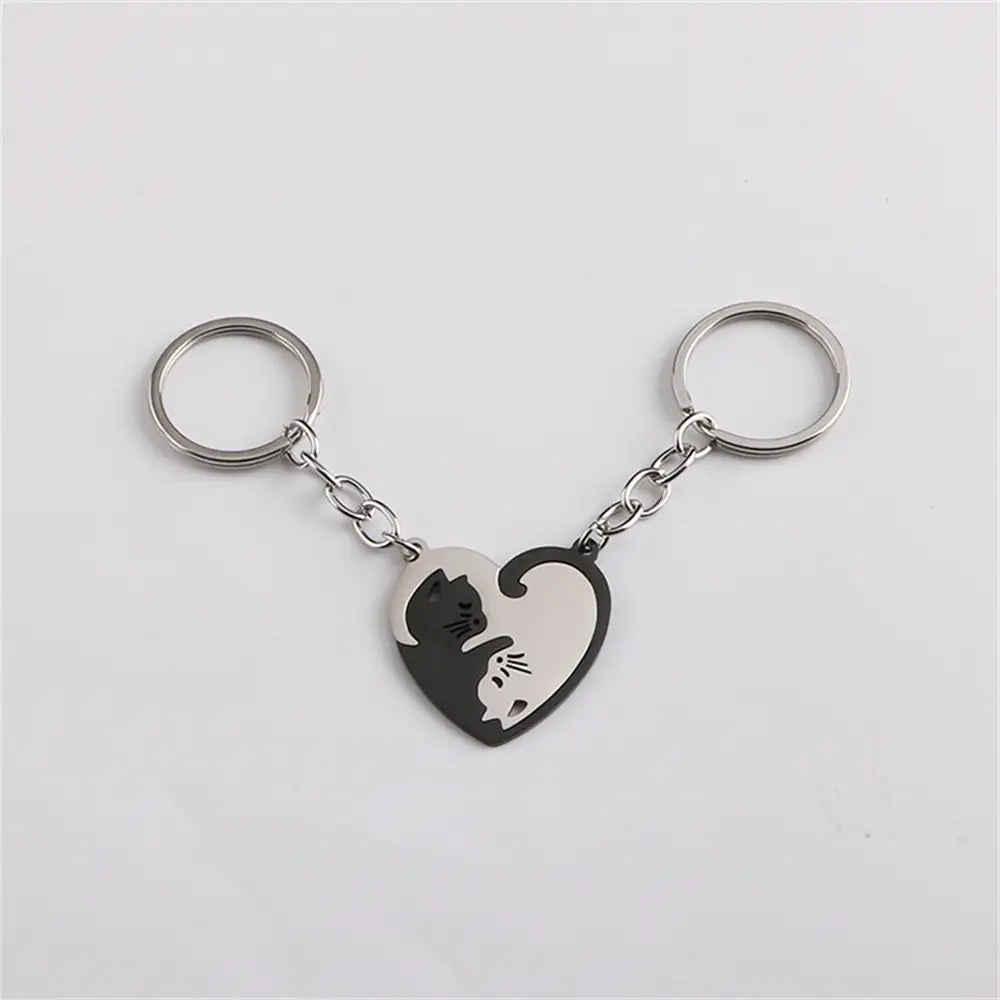 Silver heart-shaped keychain featuring a black and white yin-yang cat design from the interlocking cat couple keychain set.