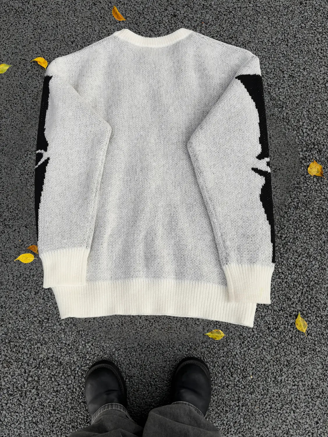 Pull gothique à jacquard squelette en maille gris pour hommes, avec des manches graphiques noir et blanc, ainsi qu’un ourlet et des poignets côtelés.