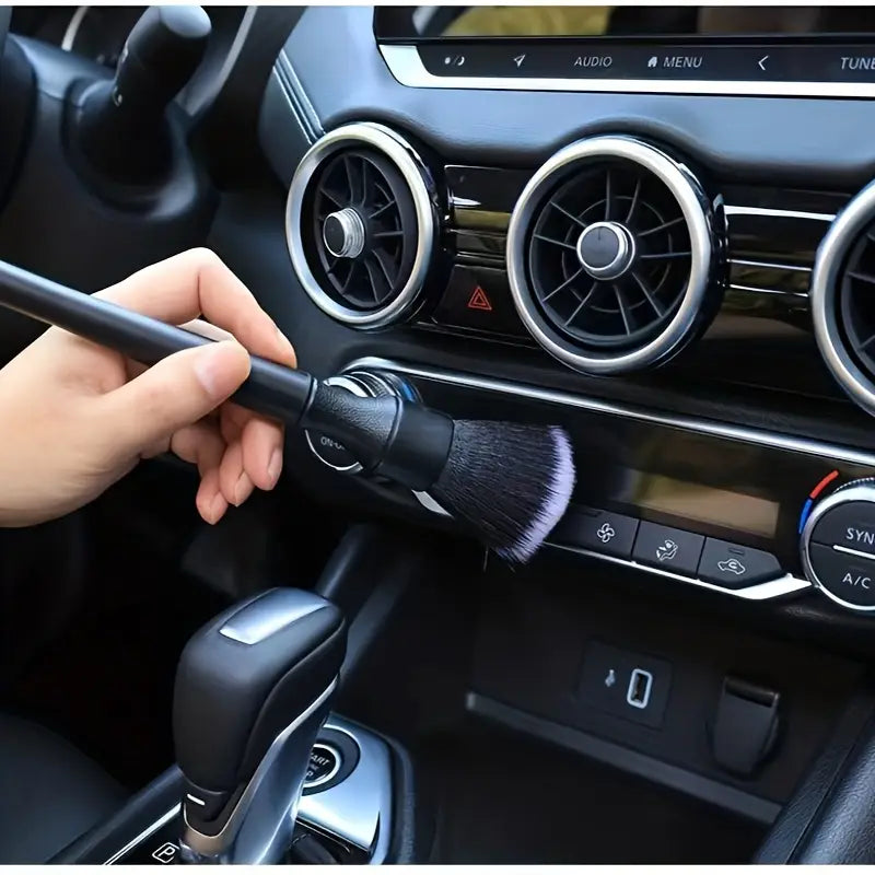 Detailreinigungsbürste für den Innenraum eines schwarzen Fahrzeugs mit weichen Borsten und einem eleganten Griff, ausgelegt für eine präzise Reinigung.