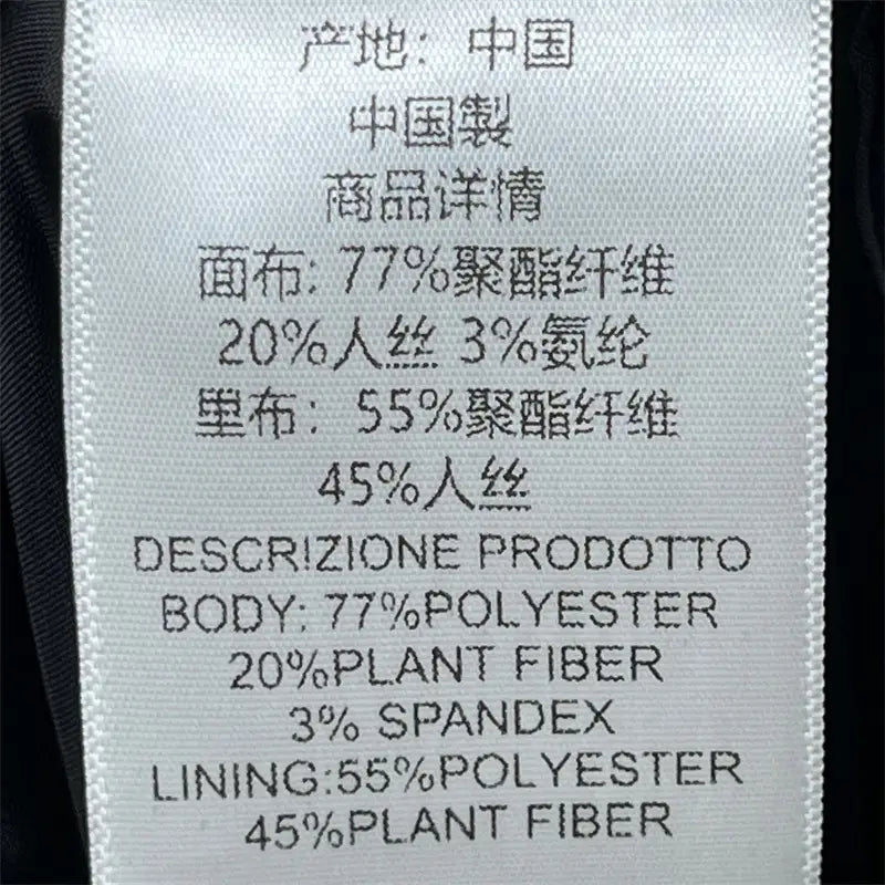 Étiquette blanche d’entretien du tissu avec texte noir détaillant la composition de la jupe crayon grise taille haute de longueur genou au style Y2K, en chinois et en anglais.