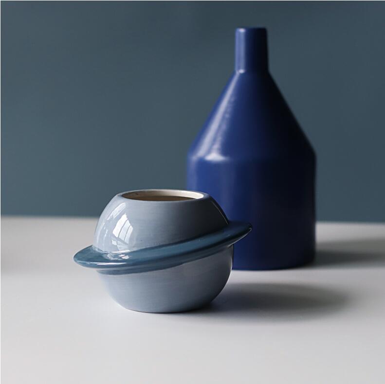 Ein eleganter hellblauer Keramik-Planeten-Sukkulenten-Topf als Desktop-Pflanzgefäß mit einer Eierbecher-Designform und einem passenden Ring, der wie Saturns Ringe wirkt.