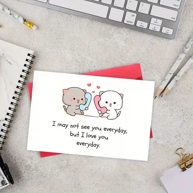 Carte de vœux pour couple de chats à longue distance blanche présentant deux chats dessinés tenant des téléphones colorés et le texte : je ne vous verrai peut-être pas tous les jours, mais je vous aime tous les jours.