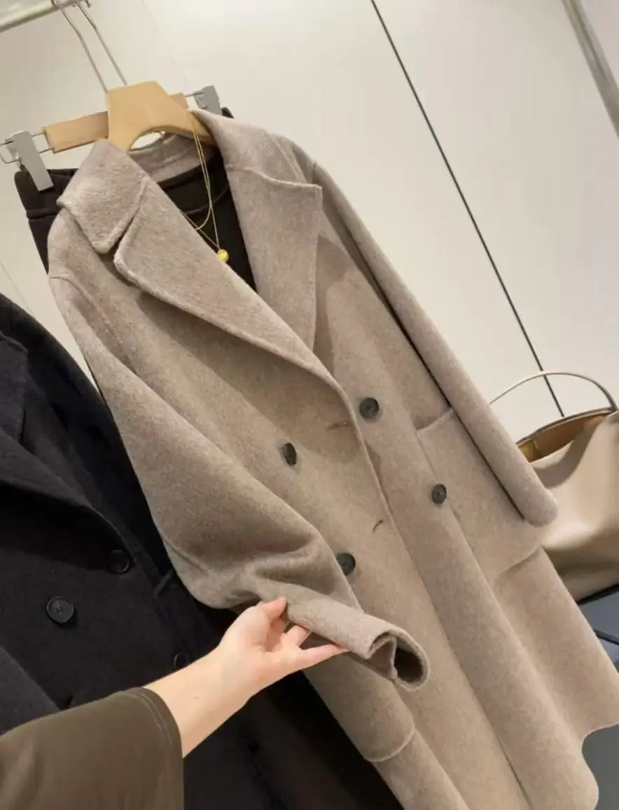 A soft beige women wool blend double breasted coat with a classic collar and dark buttons.