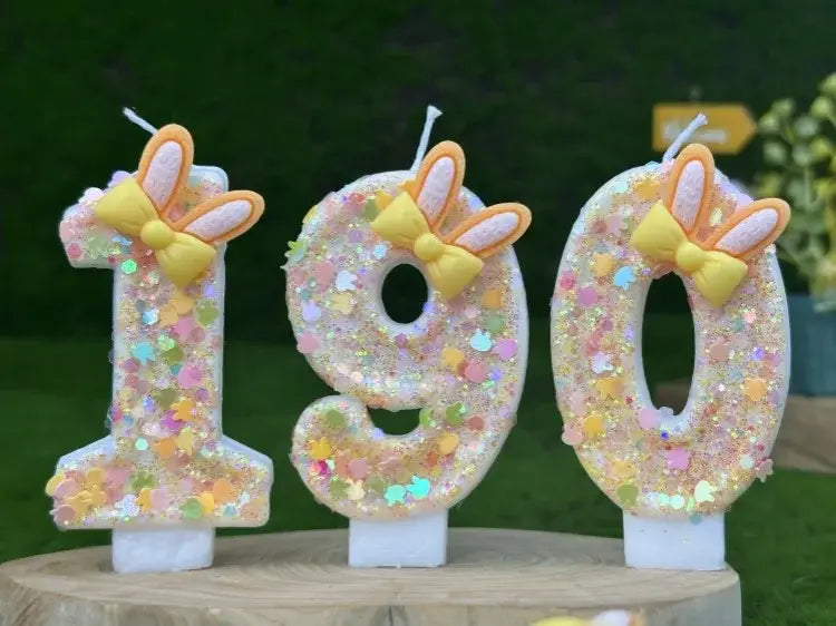 pastel-colored glittery number birthday candles shaped as 190 featuring yellow bows and orange bunny ears for festive celebrations