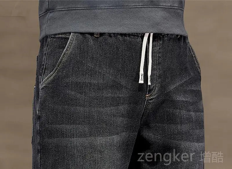 Plus size elastic waist loose straight dark-wash denim joggers with a drawstring waistband and white cord accents.