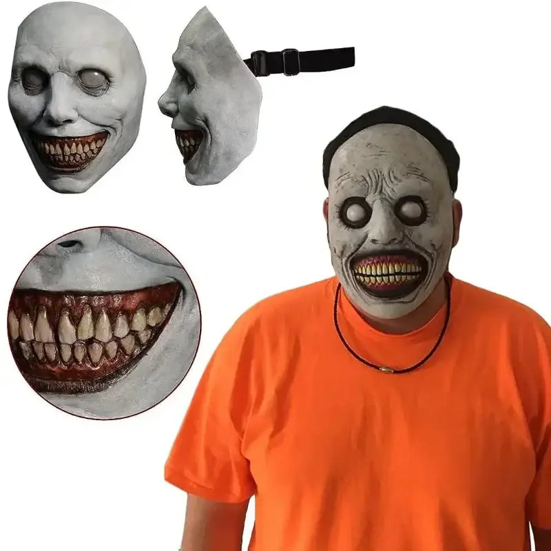 Gray latex full face horror mask with exaggerated wide grin, detailed teeth and eye sockets, and black elastic strap for creepy Halloween costume accessory.