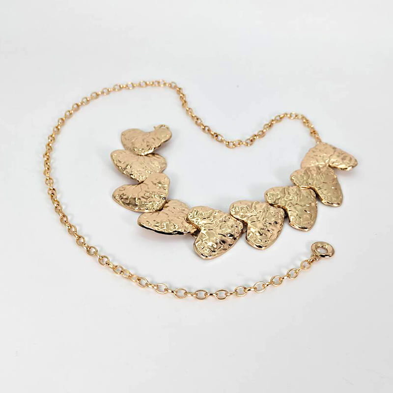 Cadena de cintura con corazón de gran tamaño en tono dorado, amante, con una serie texturizada de corazones colgantes de estilo diseñador dispuestos a lo largo de una cadena de cinturón tipo punk elegante.