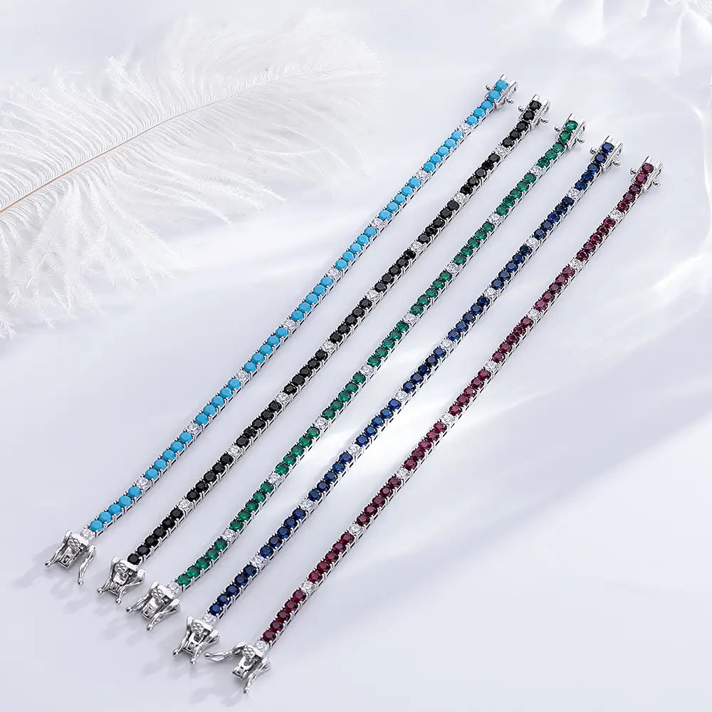 Sterling silver 3mm tennis bracelet set featuring black cubic zirconia with accent diamonds alongside four additional bracelets in turquoise, black onyx, emerald, sapphire, and ruby gemstones.