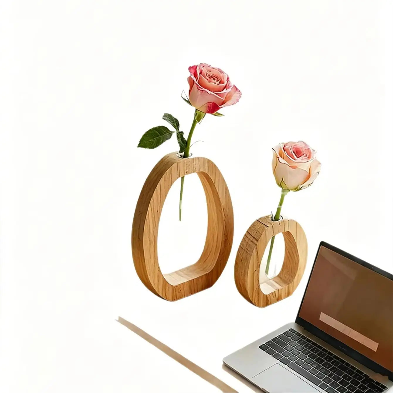 Zwei minimalistische ovale Holz-Glas-Bud-Vasen, in denen jeweils eine einzelne rosa Rose als Schreibtischdekoration verwendet wird.