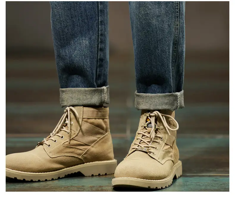 men loose denim harem jeans paired with tan suede combat boots featuring beige laces and a rugged textured sole.
