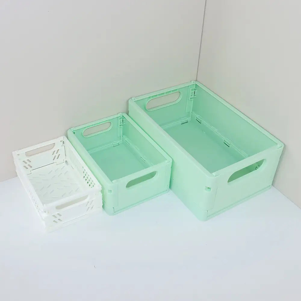 Set aus drei faltbaren pastellfarbenen Kunststoff-Aufbewahrungsboxen in Mintgrün und Weiß mit integrierten Griffen und perforiertem Design zur Belüftung, ideal als Falt-Aufbewahrungsboxen oder als Aufbewahrungsboxen-Körbchen.