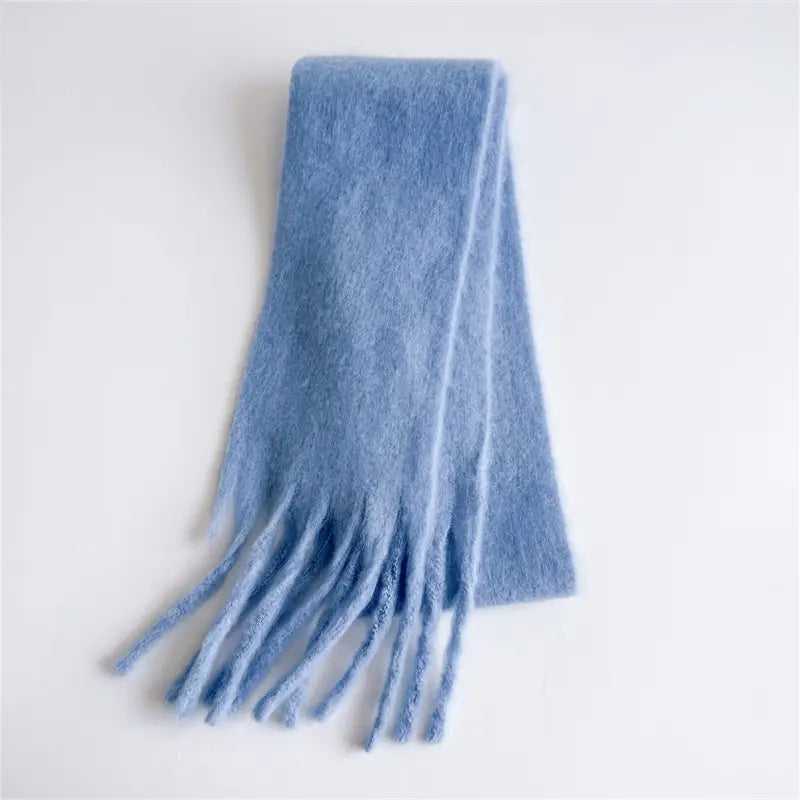 Ein weicher hellblauer Cashmere-ähnlicher Winterschal für Damen mit flauschiger Textur und dezenten Fransen.