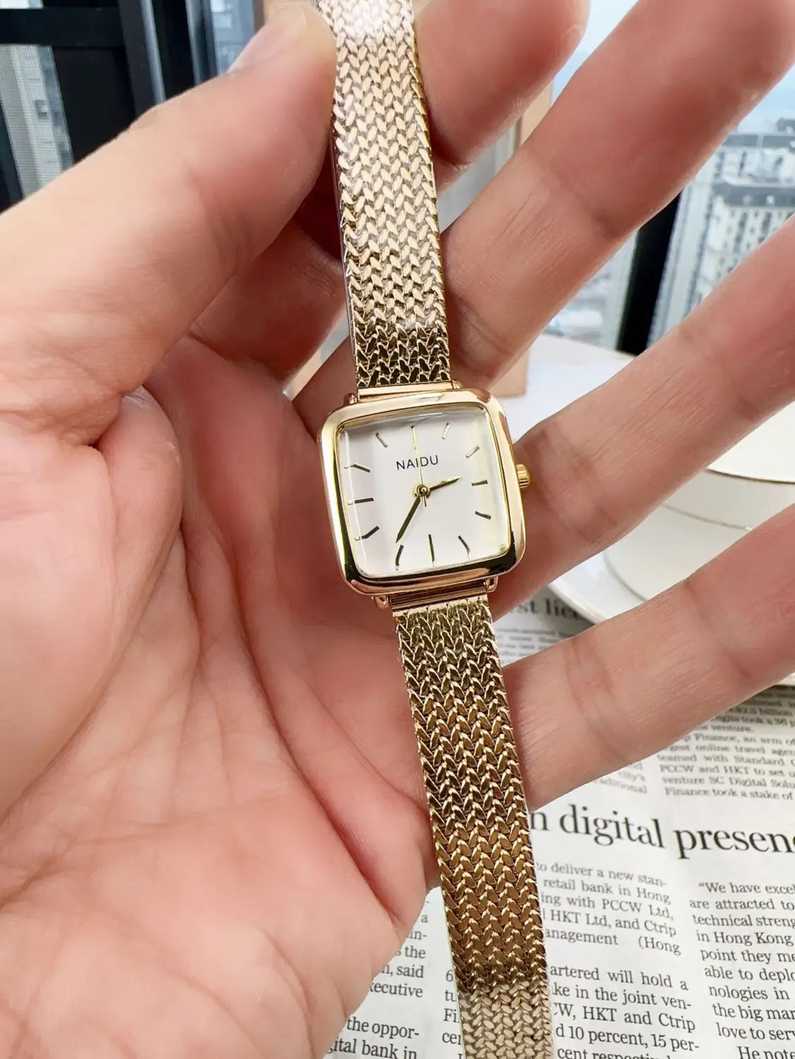 Minimalist square quartz watch for women featuring a gold mesh bracelet and a square face with minimalist black stick markers.
