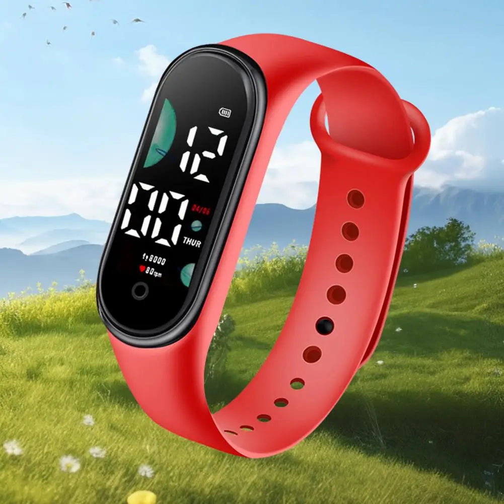 Reloj electrónico con correa de silicona roja, con pantalla de letra grande, pantalla digital negra que muestra la hora y el conteo de pasos, diseñado para uso deportivo.