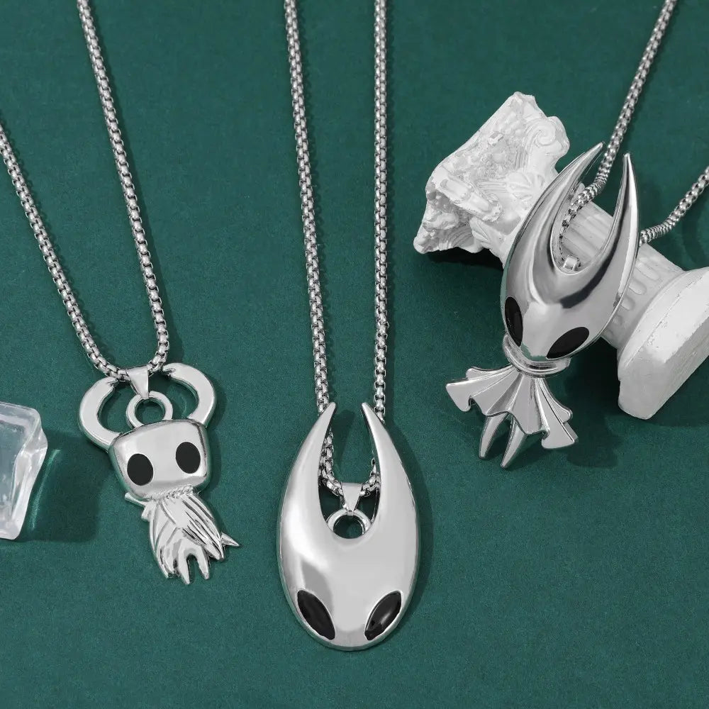 Pendentif de chevalier creux argenté avec des détails d’yeux noirs et un design stylisé élégant, pour un collier de jeu.
