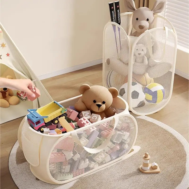 Cream-colored mesh toy storage basket with large capacity soft handles and foldable design filled with colorful toys.