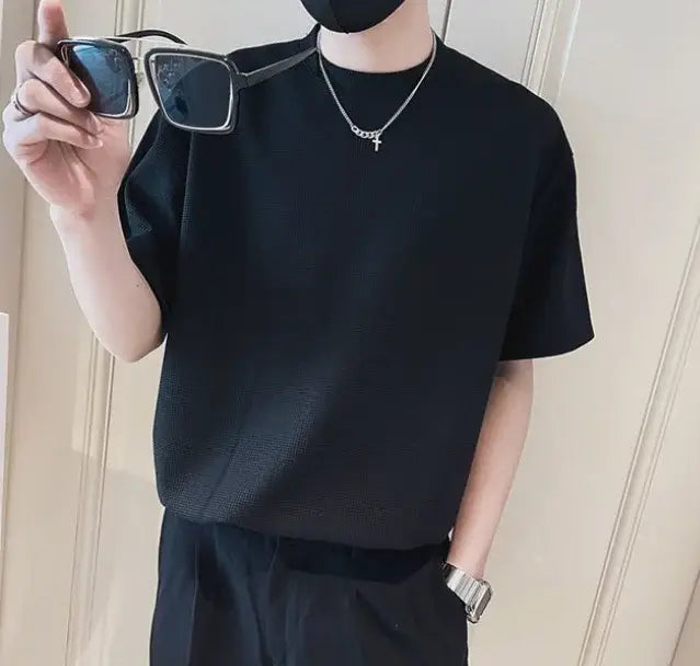 T-shirt noir pour homme à col ras du cou en maille côtelée, tissu texturé, coupe décontractée, manches courtes.