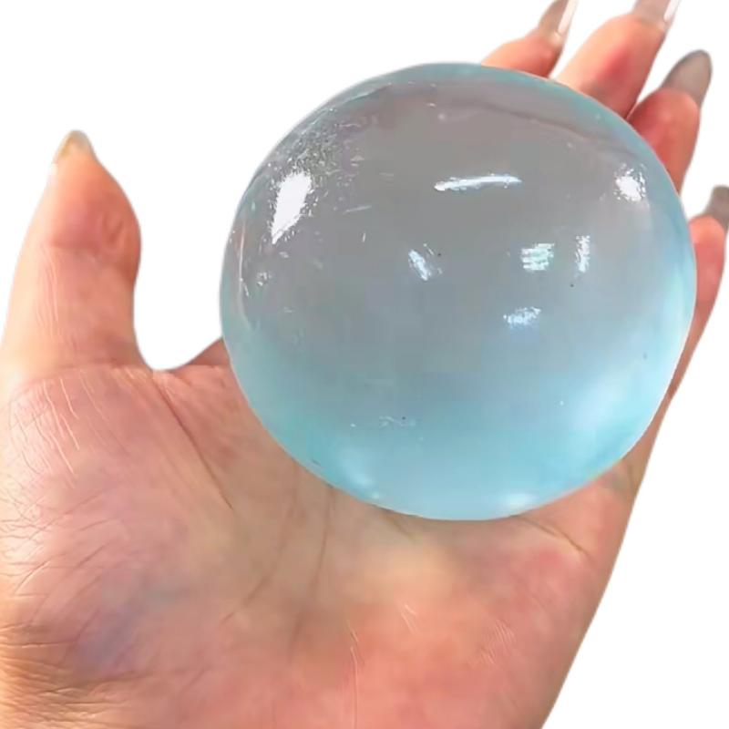 eine transluzente hellblaue Fidget-Spielzeug-Stressball-Kugel aus TPR-Material mit einer glänzenden, gelartigen Textur, die mit Kokosöl für Stresslinderung angereichert ist