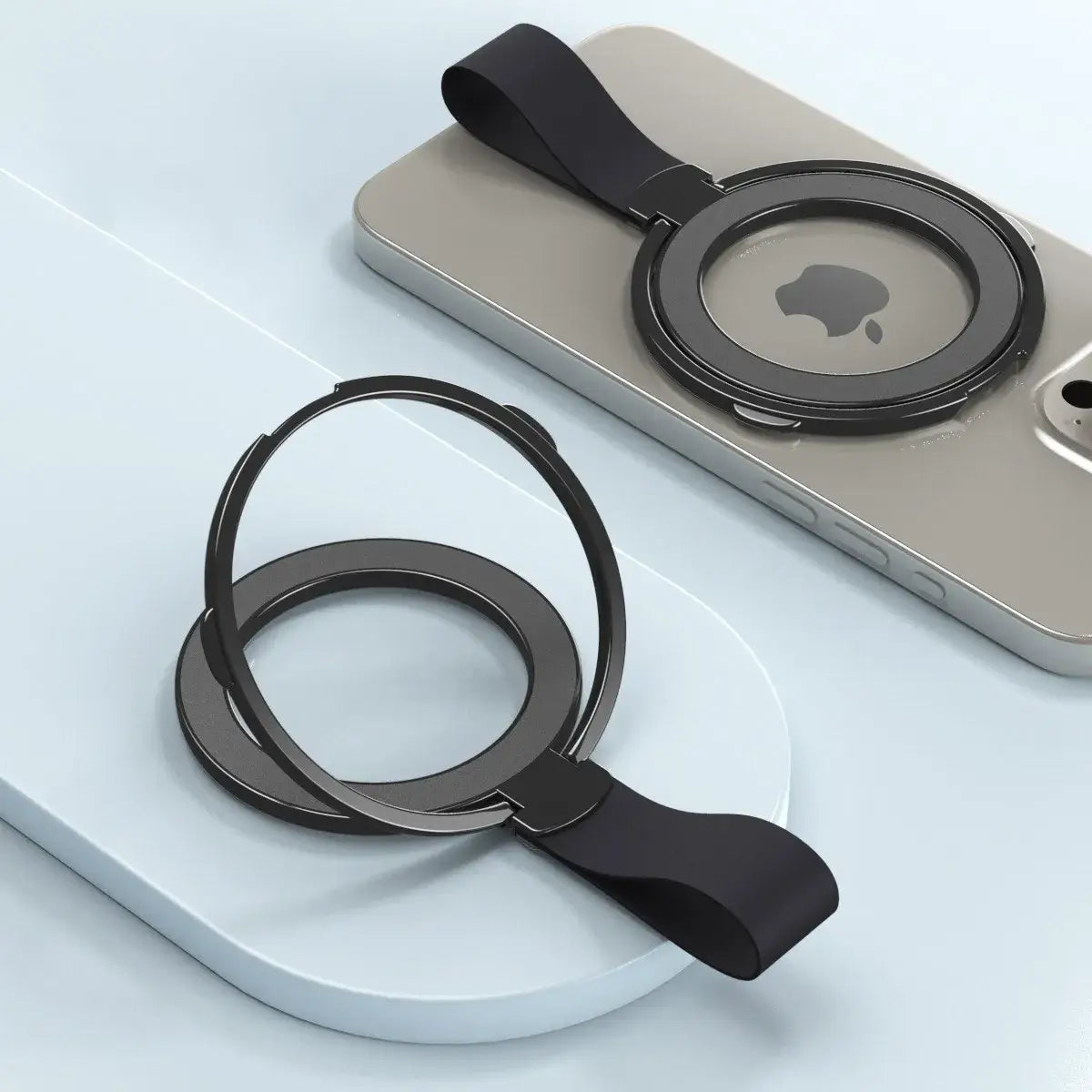 Black magnetic phone ring holder with a sleek minimalist design and soft orange silicone strap for Magsafe attachment.