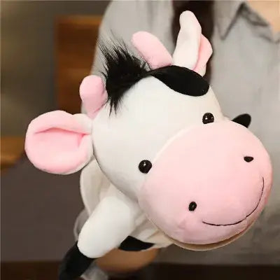 A plush cow hand finger puppet with a white body black spots and mane pink ears and nose and embroidered facial features included in educational baby toys featuring lion elephant bunny designs.