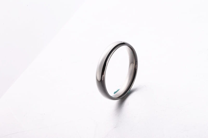 A sleek minimalist stainless steel wedding band with a smooth polished finish and slightly rounded edges in rose gold color measuring 6mm.