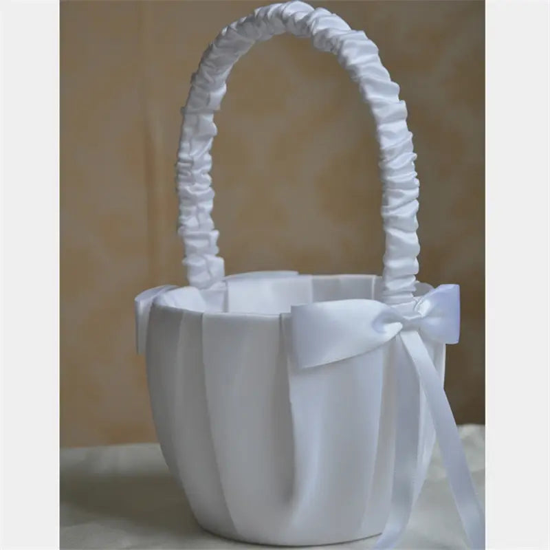 Panier de demoiselle d’honneur en satin blanc avec anse froncée et détail de nœud perlé assorti.