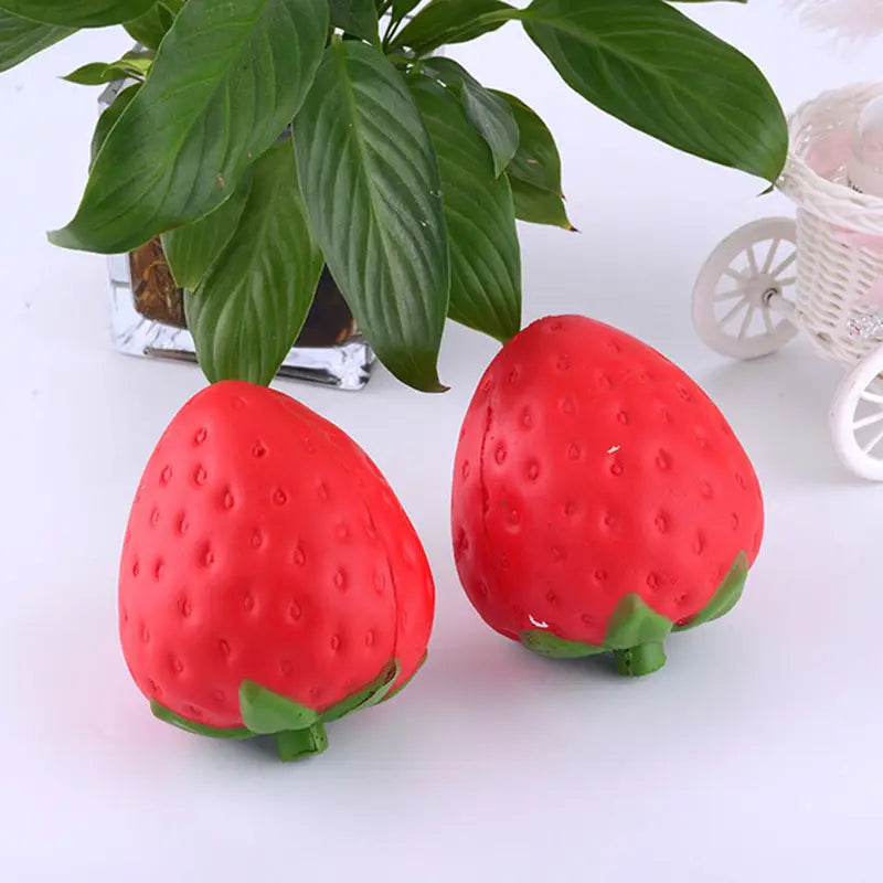Juguetes antiestrés de fresa roja con forma de fresa, que se eleva lentamente y es blandamente esponjoso, con partes superiores de hojas verdes y superficies texturizadas, diseñados para aliviar el estrés.