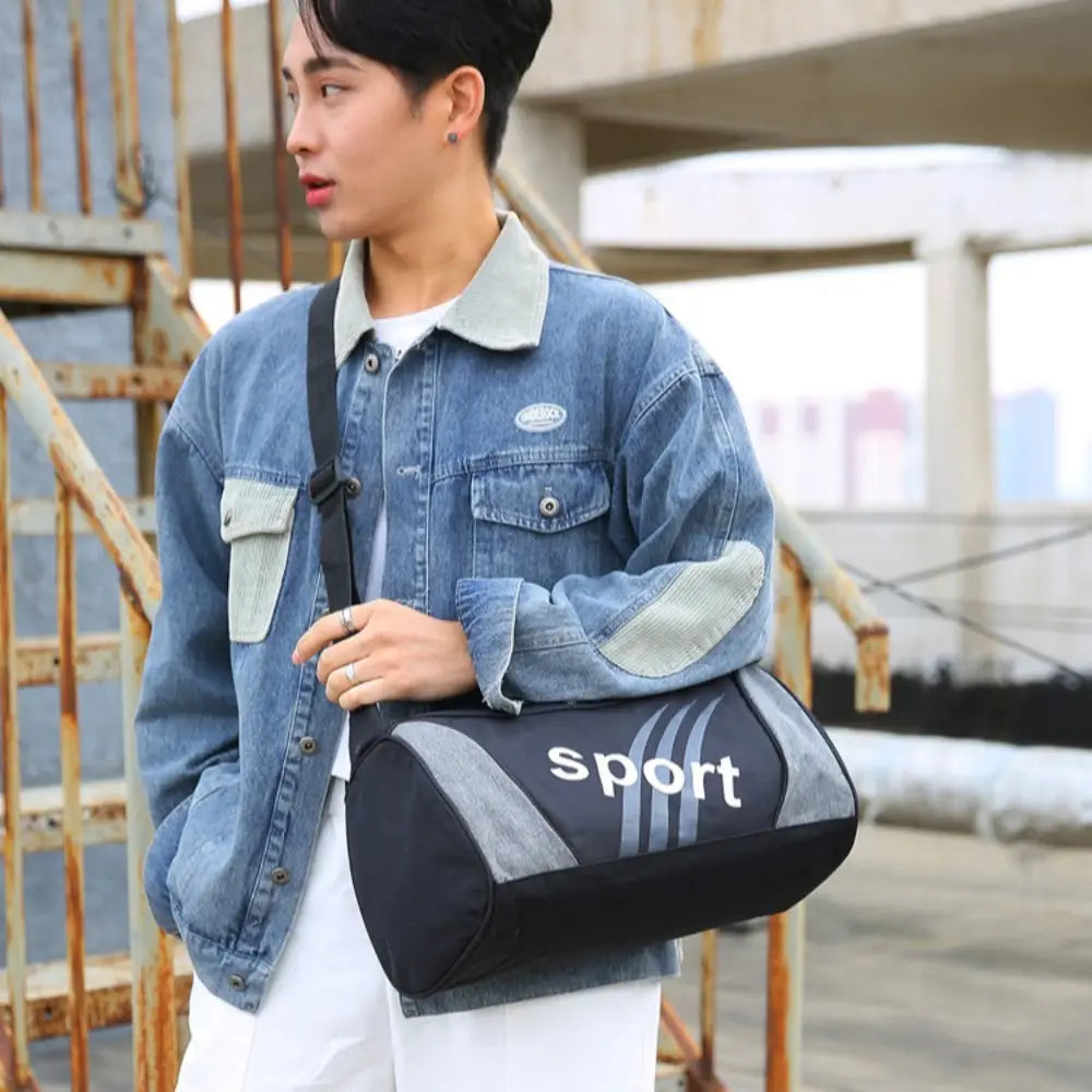 Petit sac de sport noir et gris avec inscriptions sportives blanches, conçu pour l’entraînement de sports en salle de sport comme un sac duffel à porter en bandoulière.