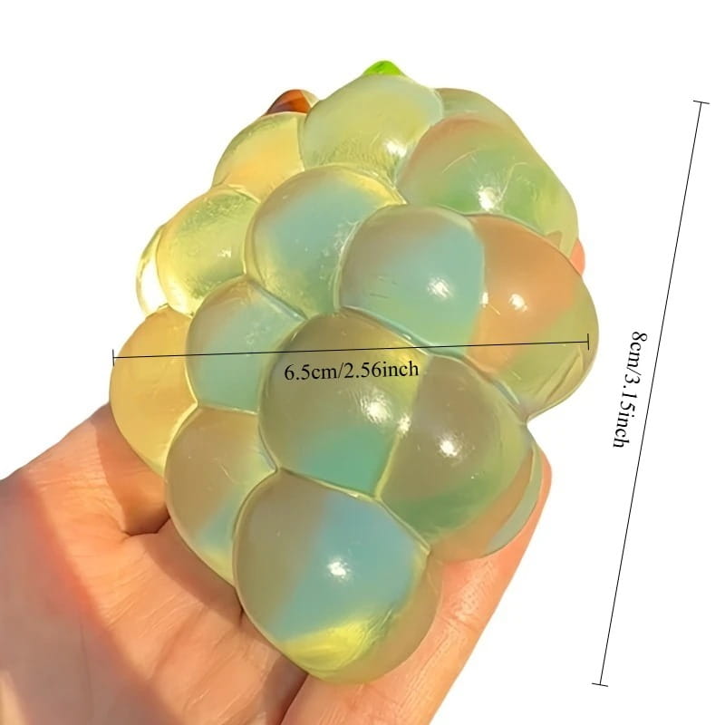 Ein transparenter, mehrfarbiger Silikon-Traubencluster-Stressball mit glänzender Oberfläche aus der Taba-licious Fun Fruit-Kollektion, ausgelegt als lustiges Frucht-Taba-Fidget-Spielzeug