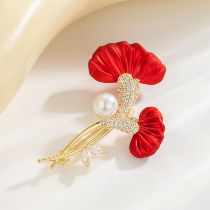 Broche à épingle délicate en perle de cristal en forme de fleur rouge, présentant des pétales en soie avec des tiges métalliques à ton doré et un accent de perle central orné de rhinestones étincelants.