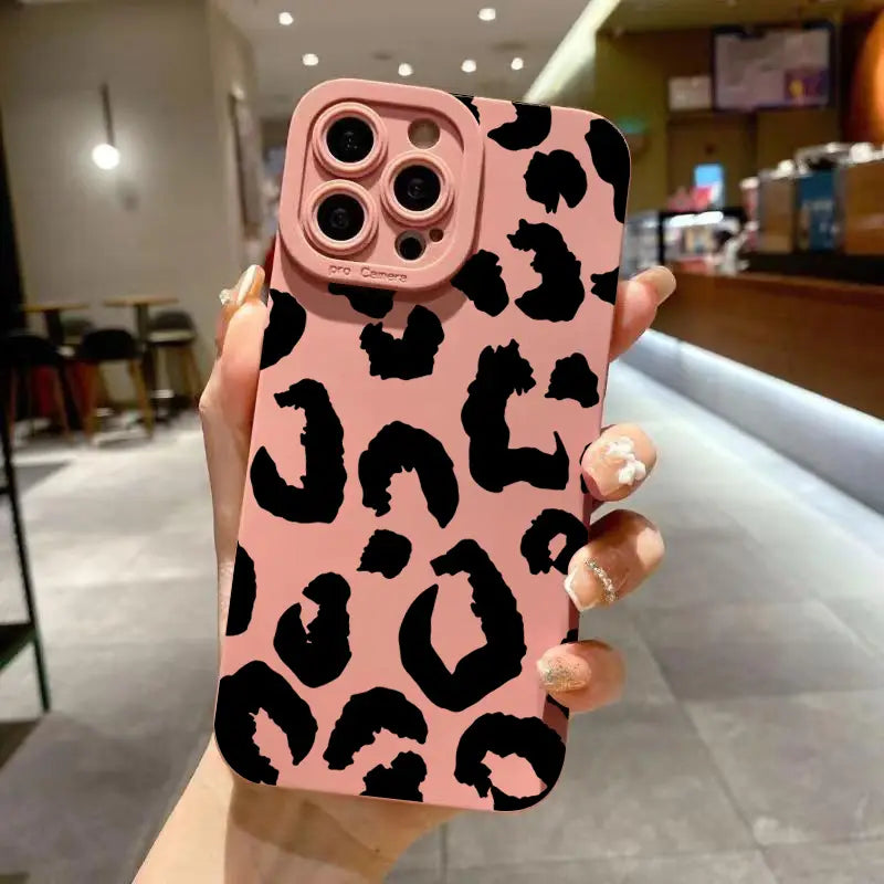 Back side of a pink leopard-print matte black camera protective iPhone Pro case with black spots.