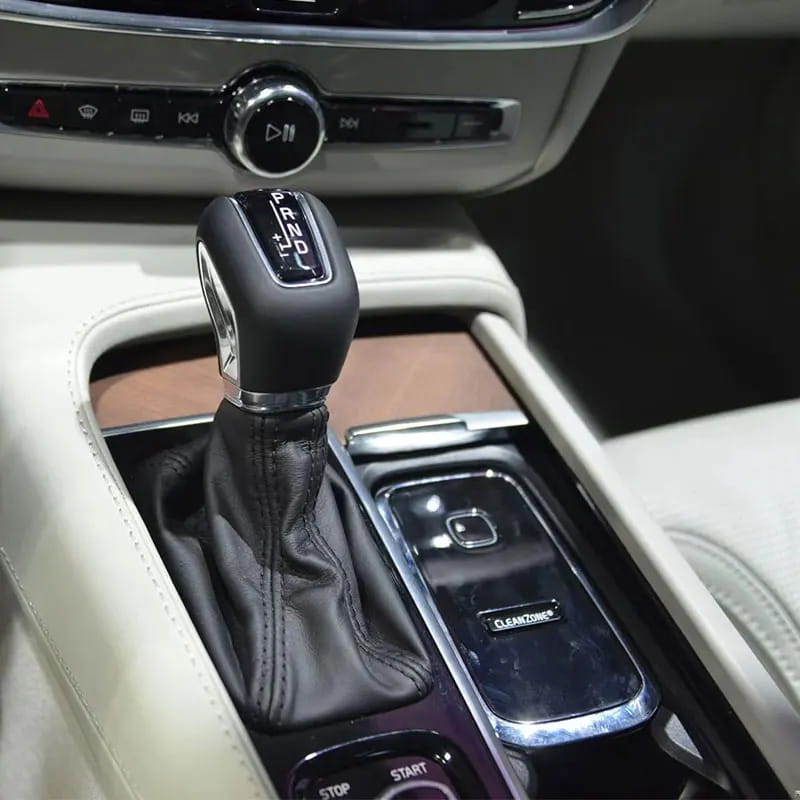 volvo cleanzone wireless car charger and air purifier featuring a black leather-wrapped gear shift knob with chrome accent and engraved p r n d markings