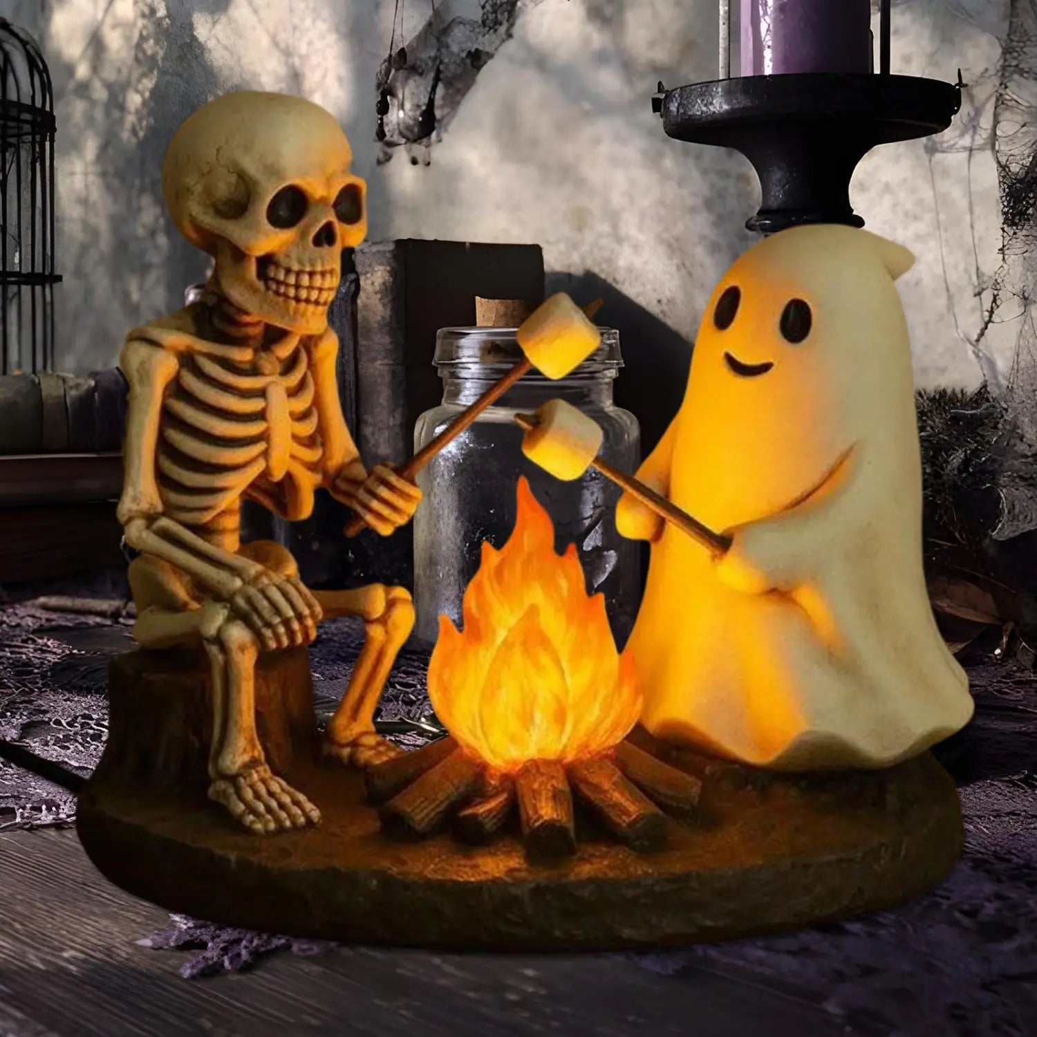 une lanterne de nuit de feu de camp fantomatique translucide jaune brillante avec un visage souriant, assise à côté d’un fantôme squelette, près d’un feu de camp, pour la décoration d’Halloween