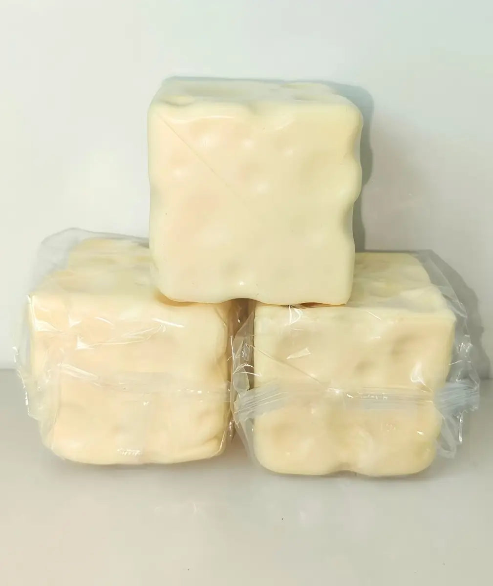Drei blassgelbe, würfelförmige Käsewürfel-Stressbälle, in klarem Kunststoff verpackt zur Sinneswahrnehmung.