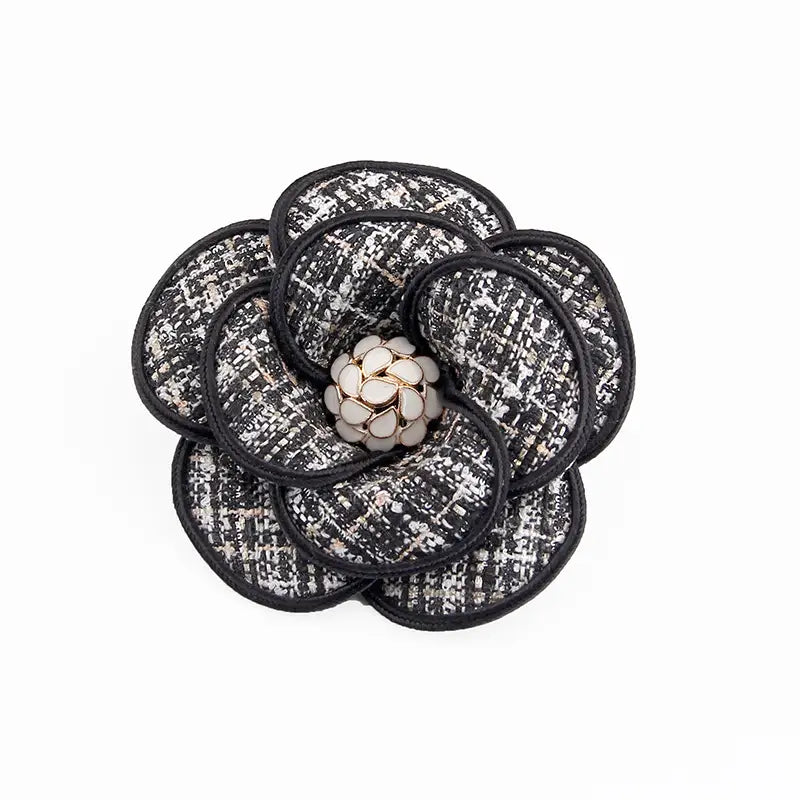 Elegante Brosche aus schwarzem und weißem Tweed-Kamelienstoff mit einer zentralen, perlenartigen Verzierung für die Verwendung als Retro-Damenbrosche.