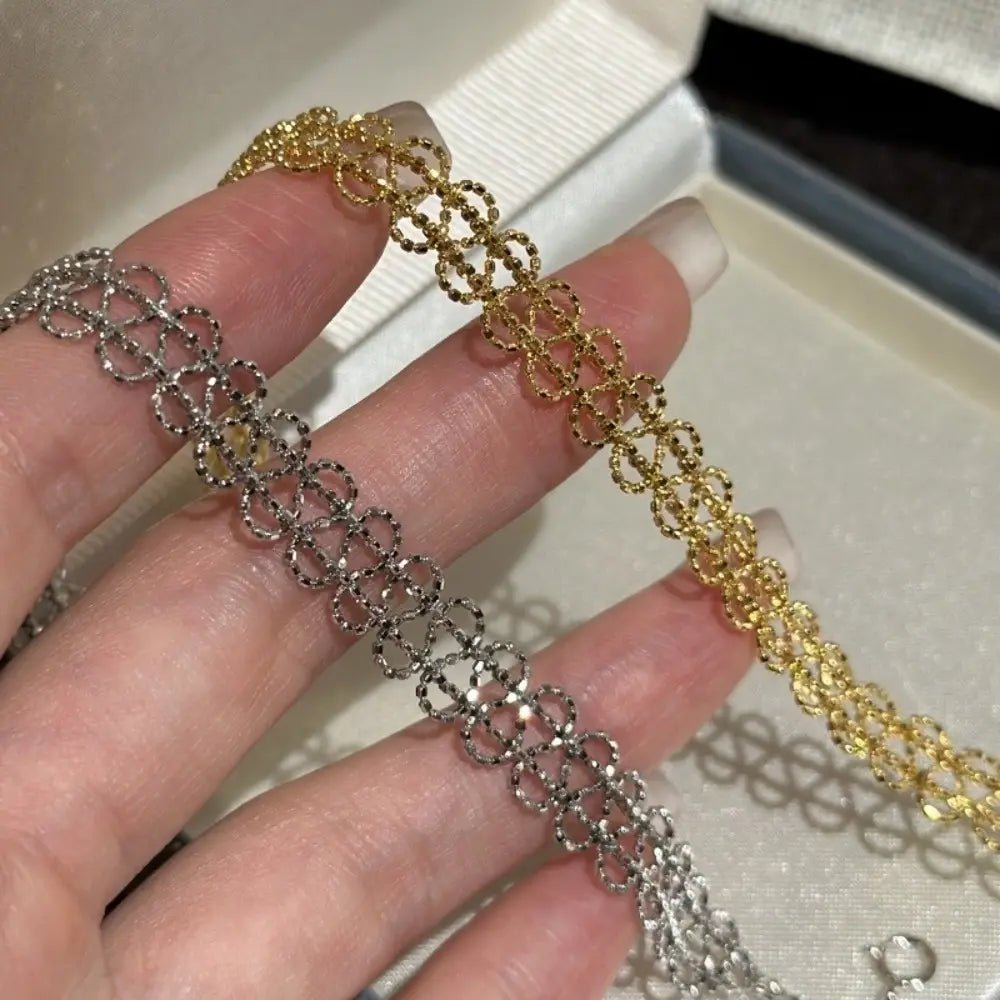Metal lace bracelet featuring an adjustable interlocking chain design in silver and gold tones with a fine intricate mesh pattern.